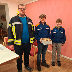 Die Schwarzenauer Jugendfeuerwehr überreicht selbstgebackene Kekse